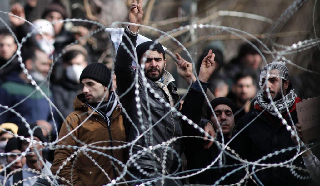 refugees held in with razor wire